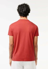 Röd kortärmad t-shirt i mjukt tyg. Med rund halsringning och en jämn yta, samt en avslappnad passform vid axlarna och ryggen.