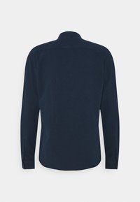 Chemise à manches longues bleu marine avec une texture lisse, un col classique et des poignets à boutons. Design simple sans motifs ni décorations.