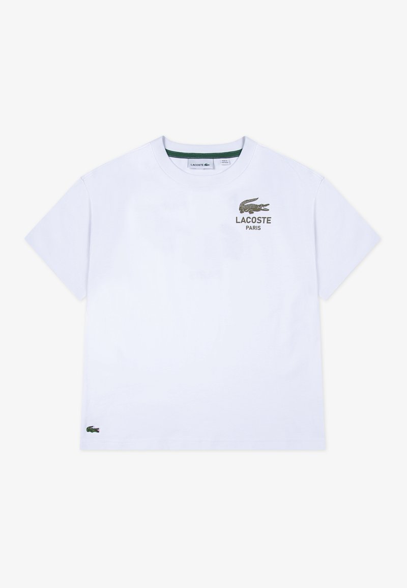 Biela tričko s krátkym rukávom s zeleným logom Lacoste a textom "PARÍŽ" na hrudi. Má klasický okrúhly výstrih a bočný detail s logom.