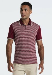 Bordeaux polo met een patroontextuur, contrasterende kraag en mouwstrepen, en een klein logo op de borst. Korte mouwen, aansluitend ontwerp.