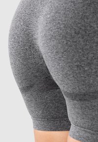 Shorts en tissu extensible gris avec une coupe ajustée, dotés d'une texture lisse et d'un ourlet qui arrive juste au-dessus du genou. Aucune motif ou accessoire visible.