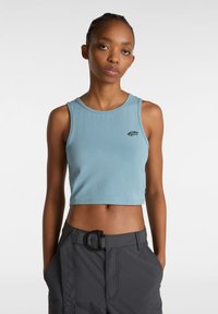 Ljusblå crop top i mjukt material. Har en rund halsringning och en liten svart logotyp på vänster bröst. Axelpartiet är ärmlöst.