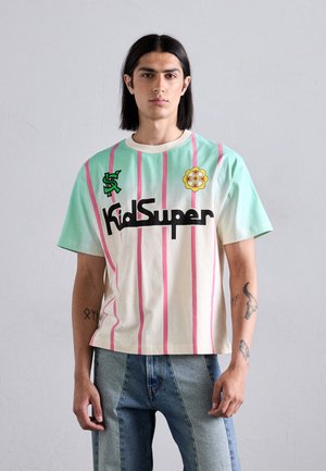 T-shirt in pastel mint and cream with pink vertical stripes. Features "KidSuper" logo and flower patch. Made of cotton with short sleeves.