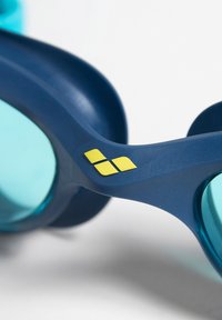 Blauwe zwembril met lichtblauwe lenzen. Bevat een gele logo aan de zijkant, een gladde textuur en een ergonomisch ontwerp voor comfort.