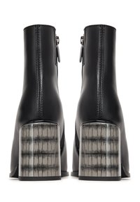 Botas de cuero negro hasta el tobillo con un tacón de bloque transparente texturizado y cremalleras laterales. Acabado liso con costuras detalladas a lo largo de las uniones.