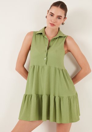 Mouwloze groene jurk met een kraag met knopen, textuurstof, tiered ruches aan de zoom en een ontspannen pasvorm.