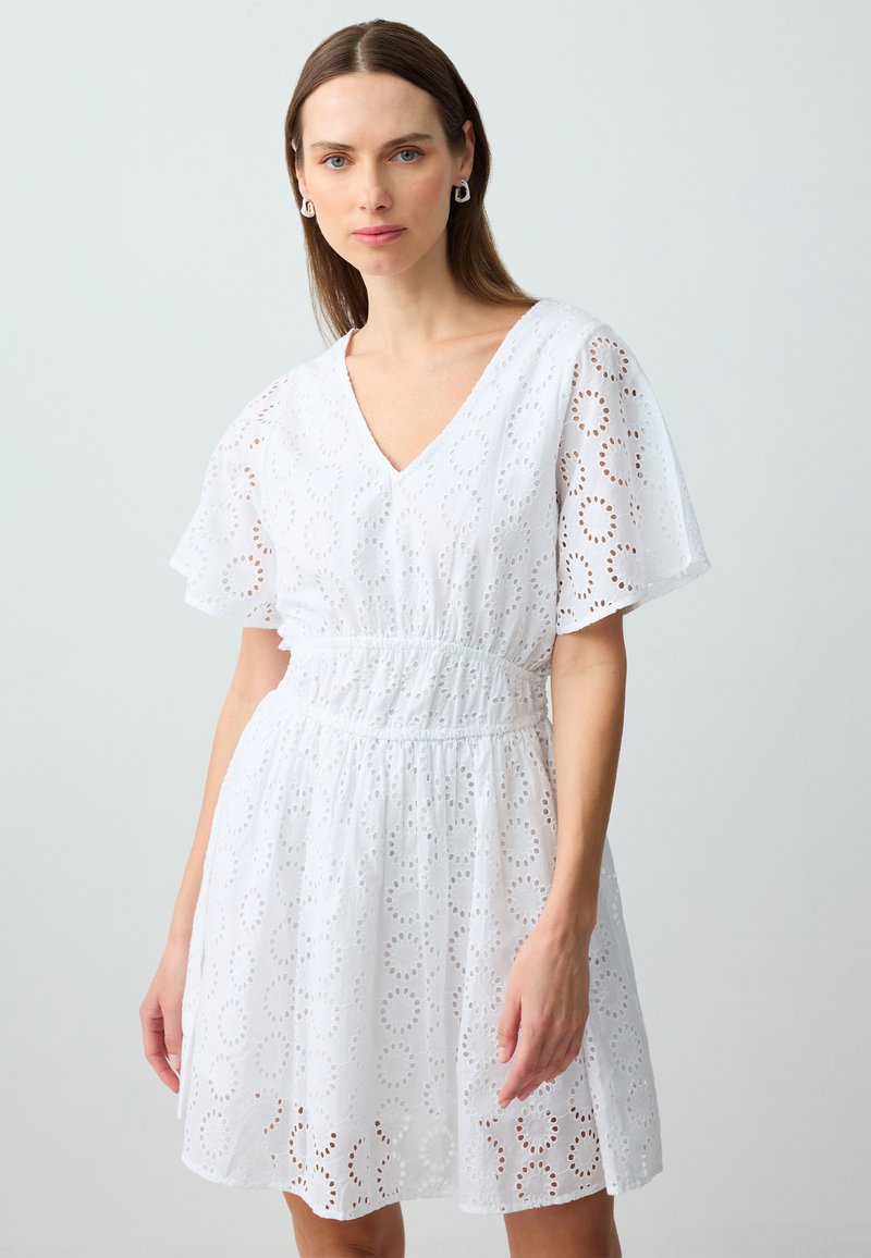 Weisses Kleid aus Lochstickerei mit V-Ausschnitt, kurzen, flatternden Ärmeln, elastischem Bund und kreisförmigen Ausschnitten throughout.
