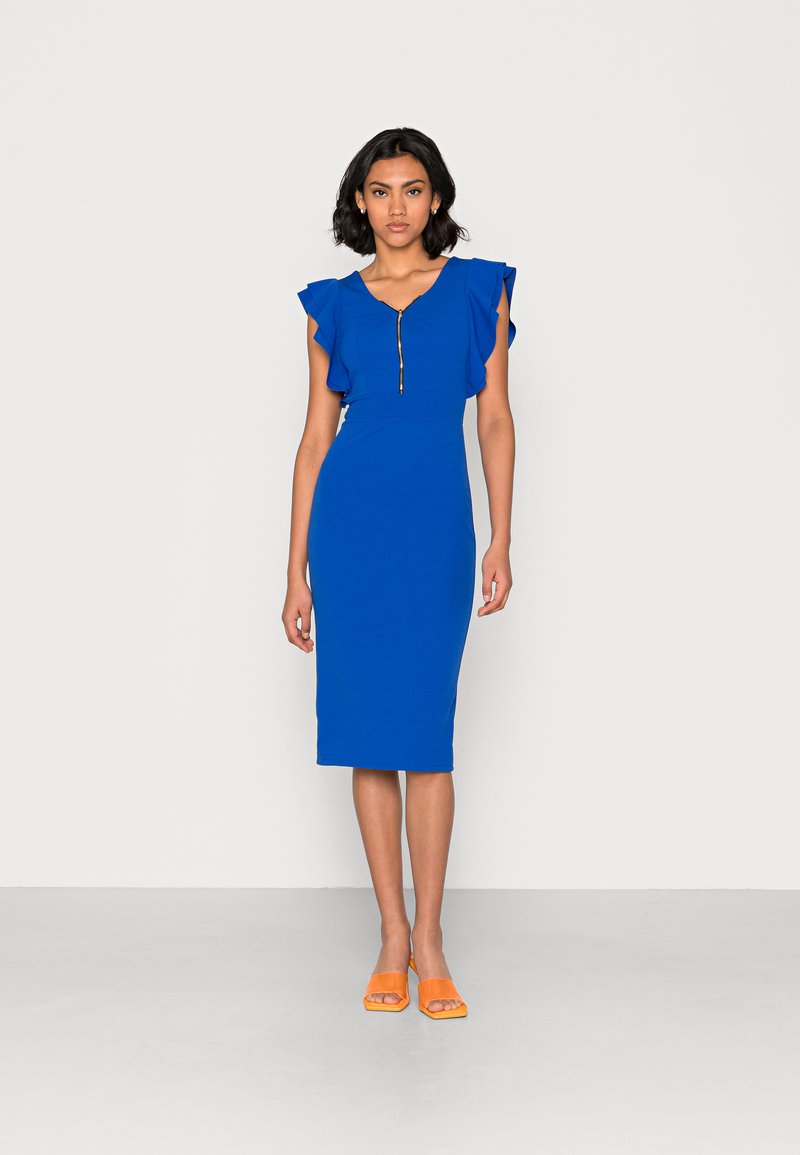 Vestido midi azul com mangas em babados, apresentando um fecho de correr na frente e uma textura suave. O modelo usa sapatos abertos laranja. Fundo liso.