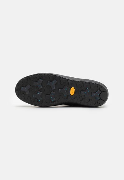 Talpă de cauciuc neagră, cu un model texturat, multi-pattern, decorată cu stropi albastre; etichetată cu "Vibram" pentru tracțiune.
