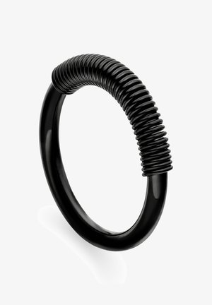 Black circular bracelet with a smooth finish and a textured, spiral-shaped accent. Made of a durable, flexible material.