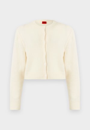 Cream-colored cropped cardigan with round neckline, long sleeves, and front buttons, featuring a red brand label inside collar.