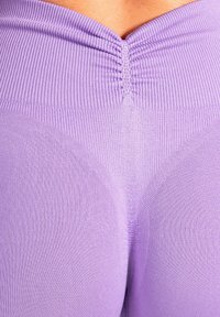Eng anliegende Lavendel-Leggings mit geripptem Bund, strukturiertem Stoff, Raffungen an der Naht, glatter Oberfläche und figurbetontem Design.
