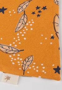 Textil mit orangefarbenem Hintergrund, verziert mit blauen Blättern, weißen Punkten und Sternen. Weiche Textur mit einem Stoffetikett am unteren Rand.