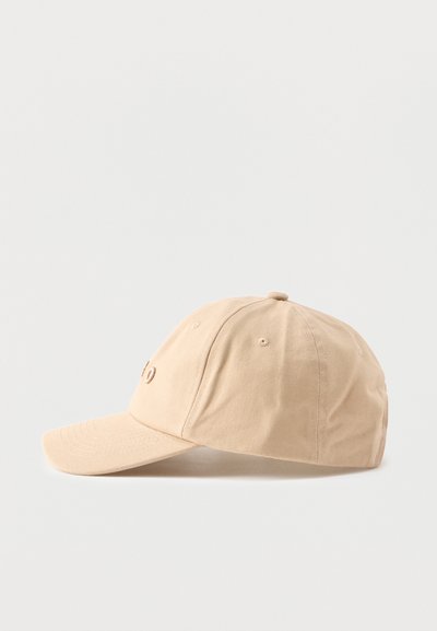 Casquette de baseball beige à six panneaux avec de petits trous de ventilation, affichée de profil sur un fond blanc uni.