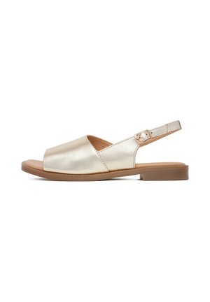 Arany fémes slingback szandál nyitott orral, lapos barna talppal és állítható boka pánttal, csattal. Simas texture és minimalista dizájn.