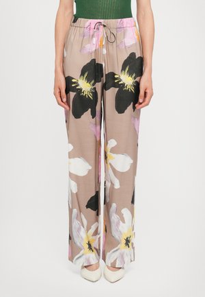 Pantaloni leggeri e fluidi in beige con grandi motivi floreali in nero, bianco e rosa; presentano una vita elasticizzata e un cordoncino.
