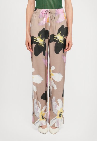 Pantalons légers et fluides en beige avec de grands motifs floraux noirs, blancs et roses ; dotés d'une taille élastique et d'un cordon de serrage.