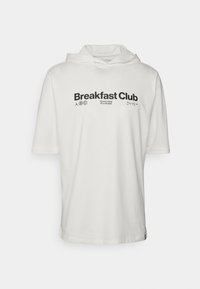 Witte hoodie met korte mouwen met de tekst "Breakfast Club" in het zwart, aangevuld met extra zinnen en logokleuraccenten aan de voorkant. Zachte stof.