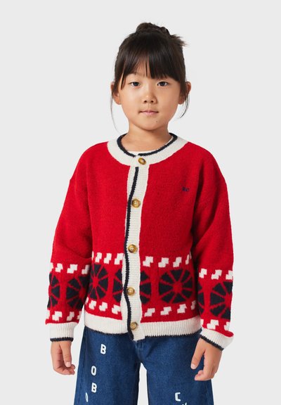 Rote Wolljacke mit cremefarbenen Akzenten und Holzknöpfen. Besitzt ein geometrisches schwarz-weißes Muster am Saum und an den Ärmeln.