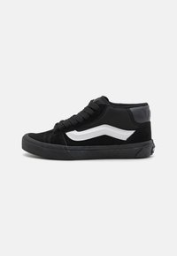 Sneakers alte nere realizzate in una combinazione di materiali scamosciati e mesh. Un accento a motivo onde bianco corre lungo il lato. Suola in gomma.