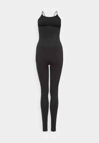 Combinaison noire une pièce sans manches avec fines bretelles spaghetti et jambes ajustées sur fond blanc.