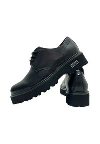 Pair of black leather lace-up shoes with thick ridged soles and metal brand tags on the sides, shown on a white background.