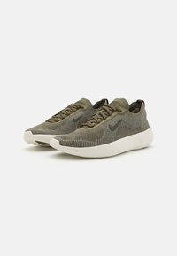 Sneakers verdi in maglia con superficie texture, caratterizzati da una suola bianca e accenti scuri, design con lacci e forma della punta arrotondata.