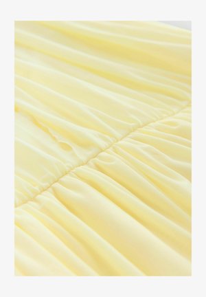 Robe jaune en tissu doux et léger avec des sections froncées au niveau de la taille, créant une texture fluide et un tombé délicat.