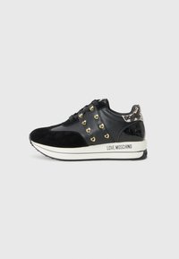 Zwarte suède en lederen sneaker met gouden hartstuds, gestructureerde hak en een witte tussenzool met "LOVE MOSCHINO" gedrukt.