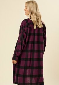 Camicia a quadri viola e nera, maniche lunghe, design con bottoni, realizzata in tessuto morbido, con una vestibilità rilassata e dettaglio sul retro.