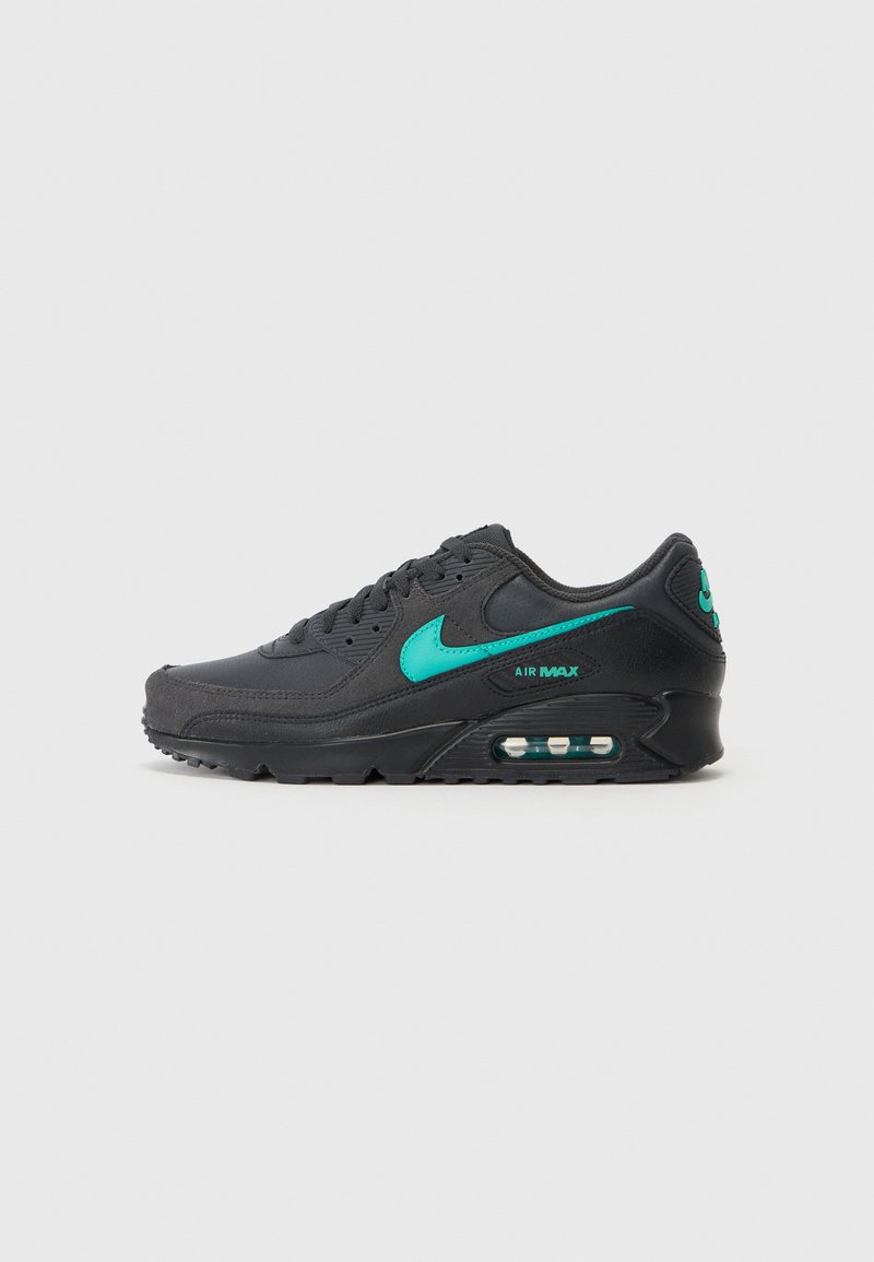 Melnas sporta kurpes ar teksturētu virsmu, ar zaļu Nike swoosh un "AIR MAX" zīmolu, un redzamu gaisa amortizācijas vienību zolē.