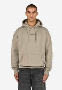 Felpa con cappuccio beige in tessuto morbido, dotata di tasca a marsupio e logo nero "PEGADOR" sul petto. Vestibilità comoda, polsini a costine.