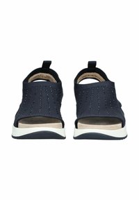 Kotníkové sandály v námořnické modré barvě vyrobené z měkkého materiálu s perforovanou texturou, s polstrovanou béžovou stélkou a bílou gumovou podrážkou.