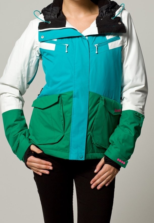 Giacca multicolore con cappuccio nero, corpo turchese e verde, due grandi tasche frontali e tasche pettorali con zip, realizzata in un materiale morbido.