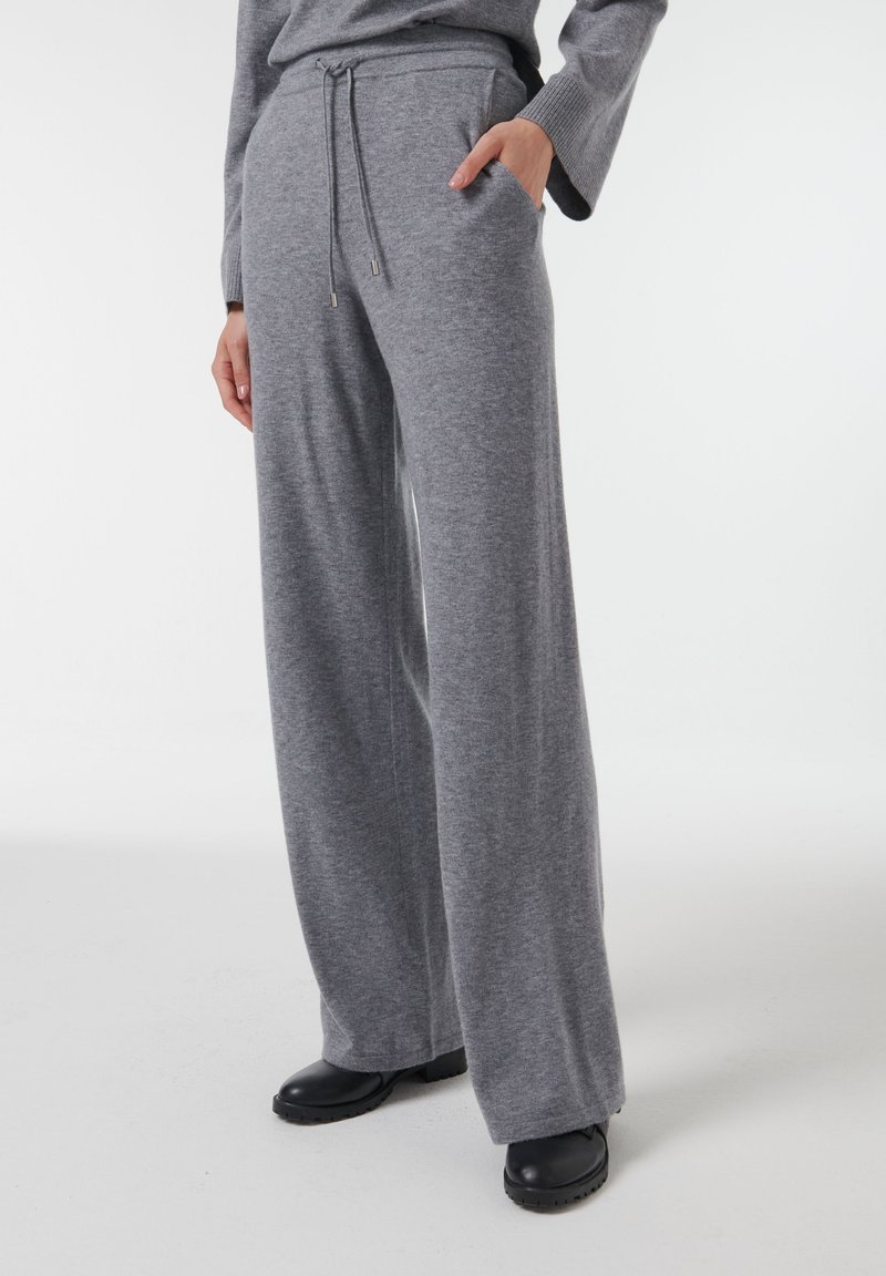 Grijze wijde sweatpants gemaakt van zacht materiaal, met een elastische tailleband met trekkoorden en zijzakken. Duurzame constructie met een gladde textuur.