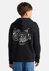 Felpa nera con cappuccio realizzata in tessuto morbido, presenta una grande grafica bianca di un serpente e testo sulla parte posteriore. Include un cappuccio e polsini a costine.