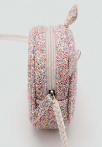 Pochette rotonda con zip realizzata in tessuto glitter multicolore, dotata di una zip color crema e di una tracolla intrecciata. Due orecchie piccole sporgono dalla parte superiore.