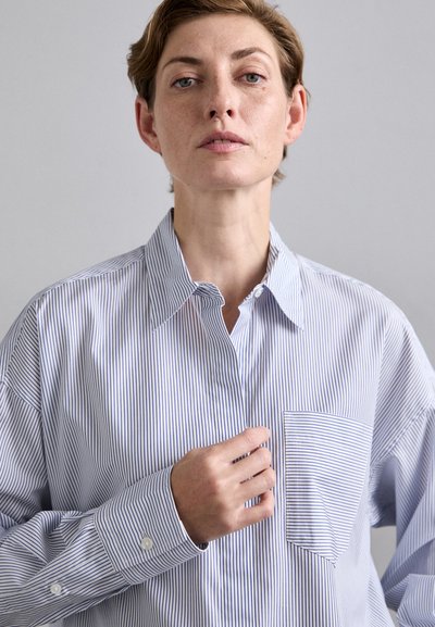Striped button-up shirt in light blue and white, featuring a classic collar, chest pocket, and long sleeves with button cuffs.