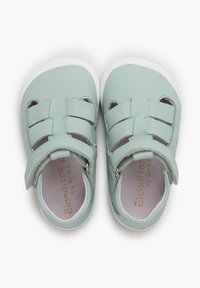 Zapatos de cuero de un verde menta claro con diseño de punta cerrada, que presentan recortes y correas de Velcro; suelas de goma blanca. Nombre de la marca grabado en el interior.