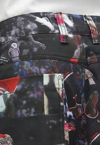 Μαύρα σορτς από ύφασμα με έντυπο φωτογραφίας μπάσκετ σε ζωντανά χρώματα. Σημαντικές λεπτομέρειες περιλαμβάνουν μεταλλικά εξαρτήματα και αντίθετη ραφή.