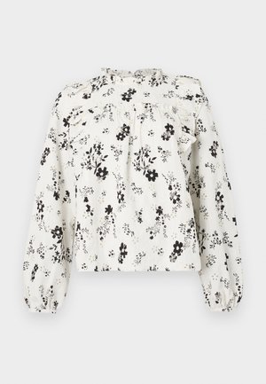 Λευκό πουκάμισο με μαύρο floral μοτίβο, διαθέτει λαιμόκοψη με βολάν, μακριά φουσκωτά μανίκια και σφιγμένη μέση, κατασκευασμένο από ελαφρύ ύφασμα.