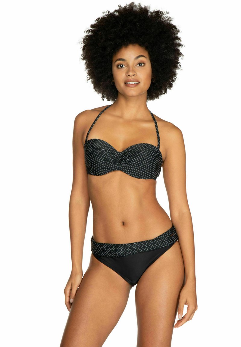 Zwart bikini set met een gevormde top met een stippenpatroon en dunne bandjes, gecombineerd met een effen zwarte onderkant met een gemusterd tailleband.