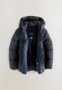 Chaqueta de plumas azul marino con capucha, que presenta secciones acolchadas, cierre de cremallera y una etiqueta interna con la marca. Textura suave y aislante.