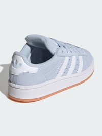 Svijetlo plava tenisica od brušene kože s bijelim trocrtastim uzorkom, okruglim vrhom, jastučićastim ovratnikom i potplatom od gume boje gume.