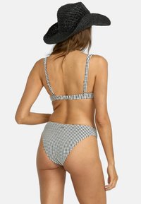 Čierno-biele gingham bikiny s nastaviteľnými ramienkami a stredným pokrytím. Zahrňuje zodpovedajúce vysoké spodné diely s hladkou textúrou.