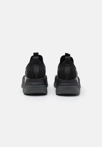 Black athletic shoes with breathable mesh fabric, padded collar, and rubber sole; features pull tabs and subtle branding on the back.