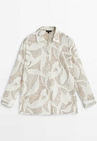 Chemise couleur crème avec un col, des manches longues et des motifs abstraits marron partout. Fabriquée en tissu léger.