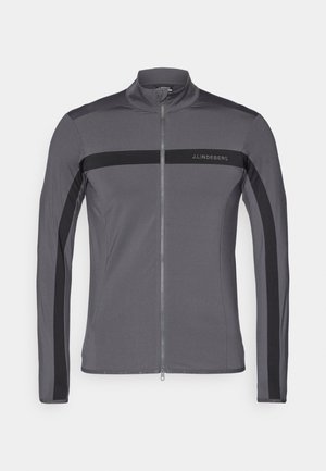 Gray athletic jacket with a high collar, full zip front, black side stripes, and logo detail. Made from smooth, stretchy fabric.