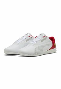 Bijele sportske cipele s modernim dizajnom, glatkim kožnim materijalom, perforiranim detaljima, crvenim naglaskom na peti i sivim vezicama. Prisutni Ferrari logo.