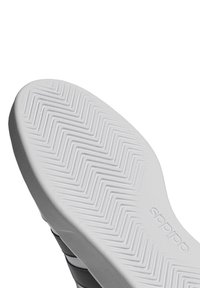 Adidas potplat tenisice s chevron uzorkom, pretežno bijele boje s sivim akcentima, glatke teksture i detaljem loga.